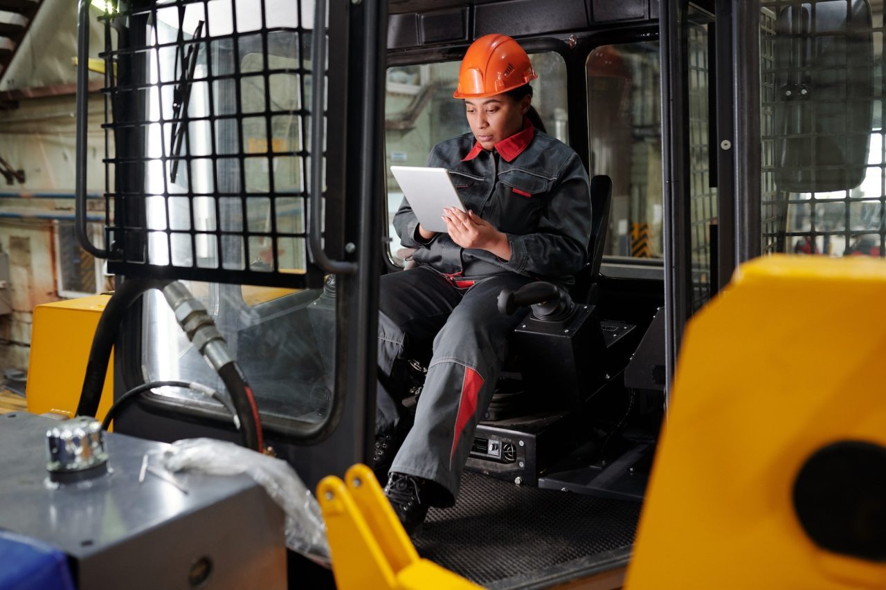 young-busy-worker-of-factory-scrolling-in-tablet-in-construction-machine.jpg